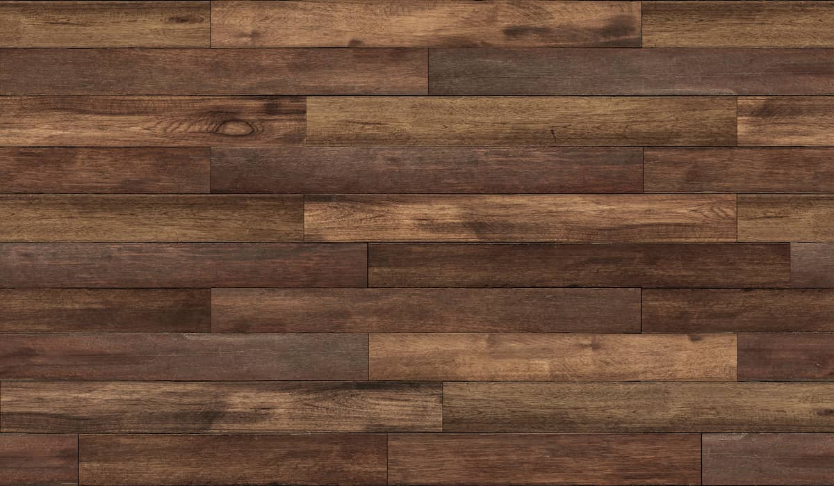 Wooden floor with horizontal planks in varying shades of brown, showing natural wood grain and texture. The planks are arranged in a staggered pattern, creating a warm and rustic appearance.